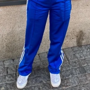 Adidas Trackpants  - Säljer mina älskade adidas Firebird i blå då de inte längre kommer till användning. Superfina verkligen och såå bra kvalite. De är straight leg o de går till marken på mig som är 166, jag har vikt ner dom lite vid midjan oxå. De är storlek XS men passar mig som för de mesta bär S, de är resår i midjan o snörning så man kan dra åt om de är för stora eller för små 