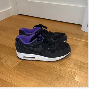Träningsskor nike - Jag säljer mina träningsskor från nike då jag ej får användning för dom längre. Dom är svarta på utsidan och lila på insidan med vit sula. Lite slitning där fram på skon (se bild 2). Är sköna att träna i och kan även användas till vardag!