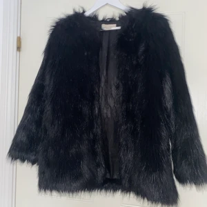 Svart jacka i storlek XS - Svart ”hårig” jacka i storlek XS! 2 st fickor framtill & försluts med 4 hakar! Köpt från h&m, originalpris 799 kr! Säljer för 500 kr, varav frakten ingår!