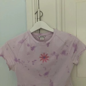 T-shirt rosa - Croppad t-shirt med lite tie die känsla och tryck av en blomma i mitten. Använd en gång. 