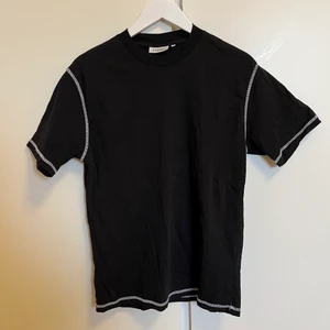 Svart T-shirt med vita sömmar - S - Svart T-shirt med vita sömmar från Junkyard. Storlek S Knappt använd Unisex Samfraktar gärna. Hör av dig vid funderingar.