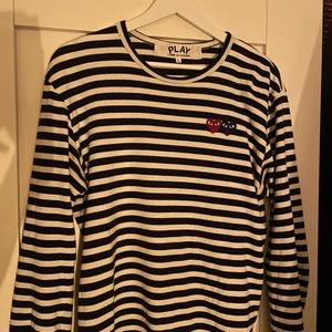 Comme Des Garçons play longsleeve - Snyggaste cdg longsleeven i storlek large, väldigt fint skick. Hyfsat liten i storleken, passar tyvärr inte mig som bär large i vanliga fall, skulle säga att den sitter som en s/m egentligen, köp direkt för 400kr