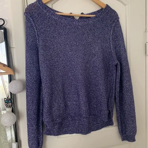 Stickad glittrig tröja - Ut och in på bilden. Lila stickat med små silvertrådar. Dragkedja i nacken. 