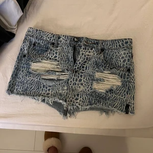 Oneteaspoon jeanskjol med mönster - Jättefin jeanskjol från Oneteaspoon med vad jag skulle beskriva som krokodilmönster! Tyvärr för liten för mig. Storlek 26 vilket motsvarar 34 / xs ungefär!                                                              Den är ganska kort så man får inte ha för stor rumpa hehe. Nypris ligger runt 899kr