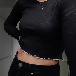 Långarmad magtröja - Säljer en super snygg och bekväm svart långarmad ribbad magtröja från boohoo med vita detaljer i kanterna. Helt oanvänd. Frakt betalas av köparen. 