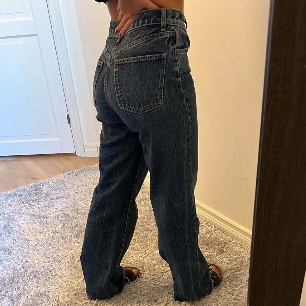 Högmidjade Jeans från ZARA i wide leg modellen. De är i stolek 36 och har triangel symbolen. Jag har klippt av dem lite själv, därav slitningarna nertill. Är 160cm, men de är långa för mig. Som visas på bild två är de lite stora i midjan bakifrån. Men framifrån syns det inte. Köptes för 399kr.. Jeans & Byxor.