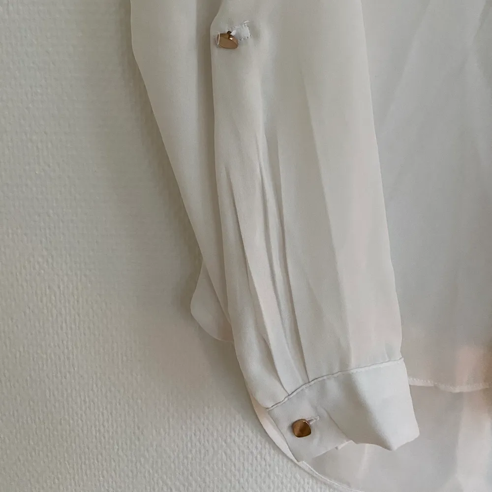En vit fin blus i tunt tyg (silke) med gulddetaljer! I storlek S, märket Amisu! Kan levereras eller mötas upp🌸. Blusar.