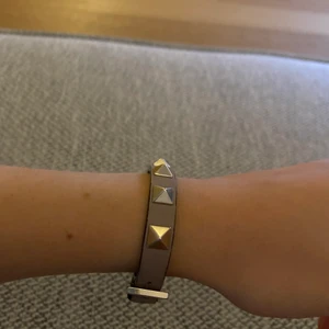 Valentino armband - Ett fint armband som använts under ca 1 års tid. Armbandet är i bra skick men har doxk lite slitningar vis spännet. Köparen står för frakten😊