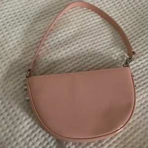 Ljusrosa axelväska - Ljusrosa axelväska i lackat läder från Margi Gaba. En jättefin märkesväska i Ljusrosa färg med silvriga detaljer. Den är utsåld på hemsidan.