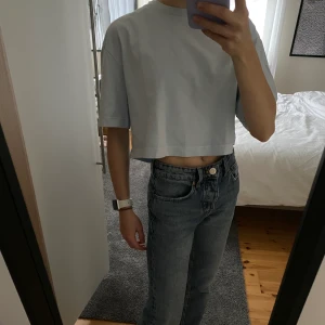 Croppad t-shirt  - Säljer en ljusblå croppad t-shirt i boxig passform i storlek xs. Tröjan är från weekday och använd någon enstaka gång bara. Säljer då den inte kommer till användning💗
