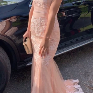 Rosa klänning med blomaktivtmaterial - Använd under ett tillfälle. Skräddarsydd. Släpet är inte så långt då den har kortats ned för att passa lite kortare personer (är 158 cm). 