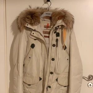 Parajumpers Masterpiece Series - En parajumper till dam i väldigt bra skick. Säljes på grund av att jag köpt en ny. Det är en vinterjacka och är väldigt varm och skön. Den är använd sparsamt och är fortfarande lika fin. Färgen är beige/kräm vit. Det är en kort modell som går till slutet av rumpan. Den har flera fickor och är äkta! Köptes för 10.500kr på Sealife Emporia i Malmö. Kvitto finns, men hittar ej för tillfället. Levererar inte, är du intresserad så möts vi och skriver ett skriftligt avtal om jag ej hittar kvittot.