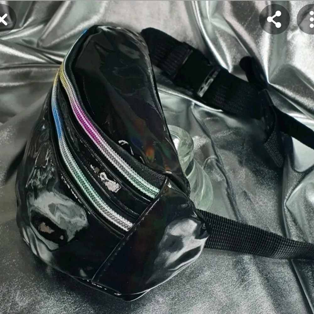 Midjeväska svart läderbältesväska, lyser med olika färger  i solljus och konstgjorda lampor.. Övrigt.