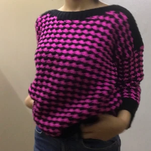 Rosa och svart stickad tröja  - En ganska oversized rosa och svart stickad tröja som skapar ett fint mönster I storlek 38 men passar allt från storlek XS-M beroende på hur du vill att det ska sitta, jag brukar ha storlek s i kläder. Är i gott skick  Skriv gärna vid frågor eller önskemål om fler bilder. (Ifall det blir pengar över från frakten betalas det tillbaka)❤️