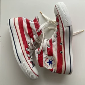 Converse US flag  - Converse med tryck av amerikanska flaggan! använda men har mer att ge. Lite slitna i gummit på kanten där fram (se bild 2). Storlek 37.