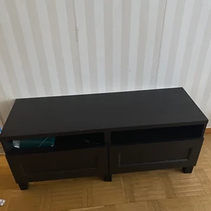 Tv bänk - Bänken är i svart fin färg och är i väldigt bra skick små skador kan finnas på den höjden är 48cm och vreden 122 cm det är två lådor man får gärna komma och kolla på den i Borås Norrby skriv privat för adressen 