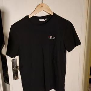 Sportig Fila T-shirt - Svart Fila T-shirt i svett-vänligt material, köpt från mansavdelningen men passar bra på mig som är storlek S-M tjej.