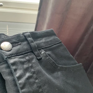 Svarta Jeans från HM-32  - Svarta jeans ifrån HM i ett något glansigare material. Passformen är något rakare men fortfarande en tightare modell. Jeansen är använda men har inga skador eller hål. Storlek 32. 