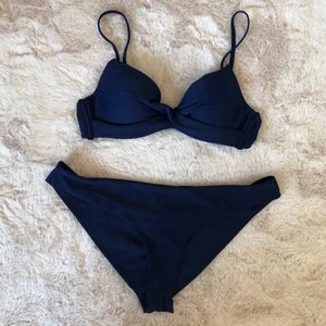 Helt nytt bikiniset  - Helt nytt bikiniset i mörkblått. Aldrig använt. Bikini-BHn är storlek 80A och nederdelen L. Justerbara band och enkelt knäppe på BHn och nederdelen har krås baktill (se bild). 