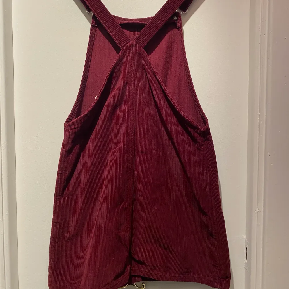 Superfint kort klänning med hängslen och fickor i vinröd manchester. Storlek XS från Topshop. Använd men i väldigt fint skick. Klänningar.