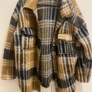 Jacka  - En brun/svart jacka i polyester och wool med knappar Modellen är oversized i S/M. Sparsamt använd 