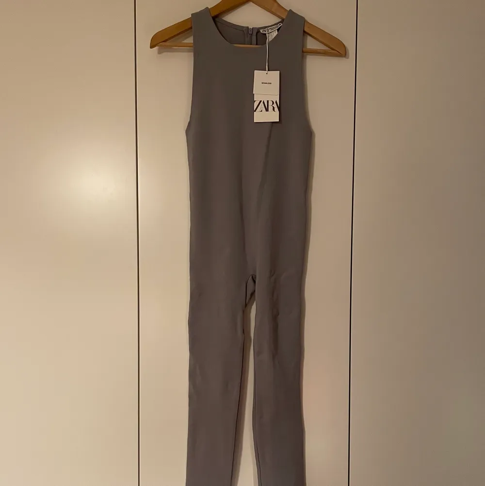 Helt ny, endast provad. Grå/lila tajt jumpsuit från Zara i storlek M-L. Stretchig och ganska tjockt material, tajt.. Klänningar.