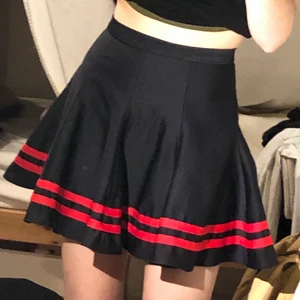 svart och röd tenniskjol i size S/XS - säljer en superfin svart tenniskjol med röda ränder. köpt secondhand och använd 3-4 gånger. fint skick! gissar på att personen som hade den innan mig sytt den själv då det inte står varken märke eller storlek på insidan. 