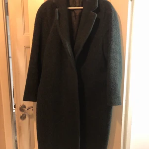 Mörkgrön kappa från & other stories - Storlek M. Köpt för 3 säsonger sedan för 2000kr. I ull. Bra skick, några nopprer som enkelt går att ta bort. 
