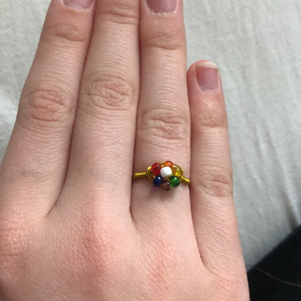 En handgjord ring med regnbågsfärgad blomma på. Väldigt fin och bra kvalite. Jag kan ändra färg på pärlorna, ändra storlek på ringen och ändra till roséguld eller silver istället för guld efter önskemål. Det är bara att kontakta mig. . Accessoarer.
