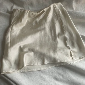 Vaniljvit satinkjol  - Vaniljvit satinkjol från ginatricot i storlek 36. (För liten för mig därför säljs den)! Den är jättefin och materialet är skönt.