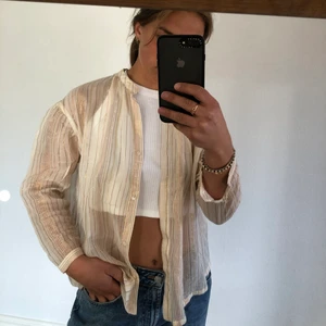 Blus - Beige/rosa blus med randiga guldiga glittertrådar i. Lite lätt genomskinlig. Väldigt fin! Från mango. Storlek S. Använd 1 gång, inga fläckar.