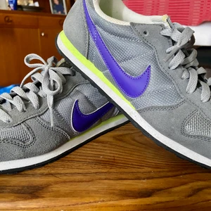 Nike ”genicco” sneakers - Beskrivning från Scorett: Ovandel i ljusgrå mesh och mocka gör att skon andas och upplevs fräsch längre. Textilfodrad med en stötdämpande EVA sula samt vadderad krage för bästa komfort. Yttersula i räfflad gummi för ett bra grepp. Genicco är sneakern som ger din outfit en härlig retrokänsla och passar lika bra på gymmet som till festen.