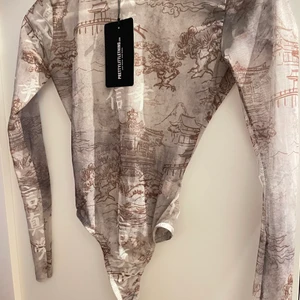 Fin body med print - Säljer denna superfina mest topp från prettylittlething.com. Trendig och fin body✨