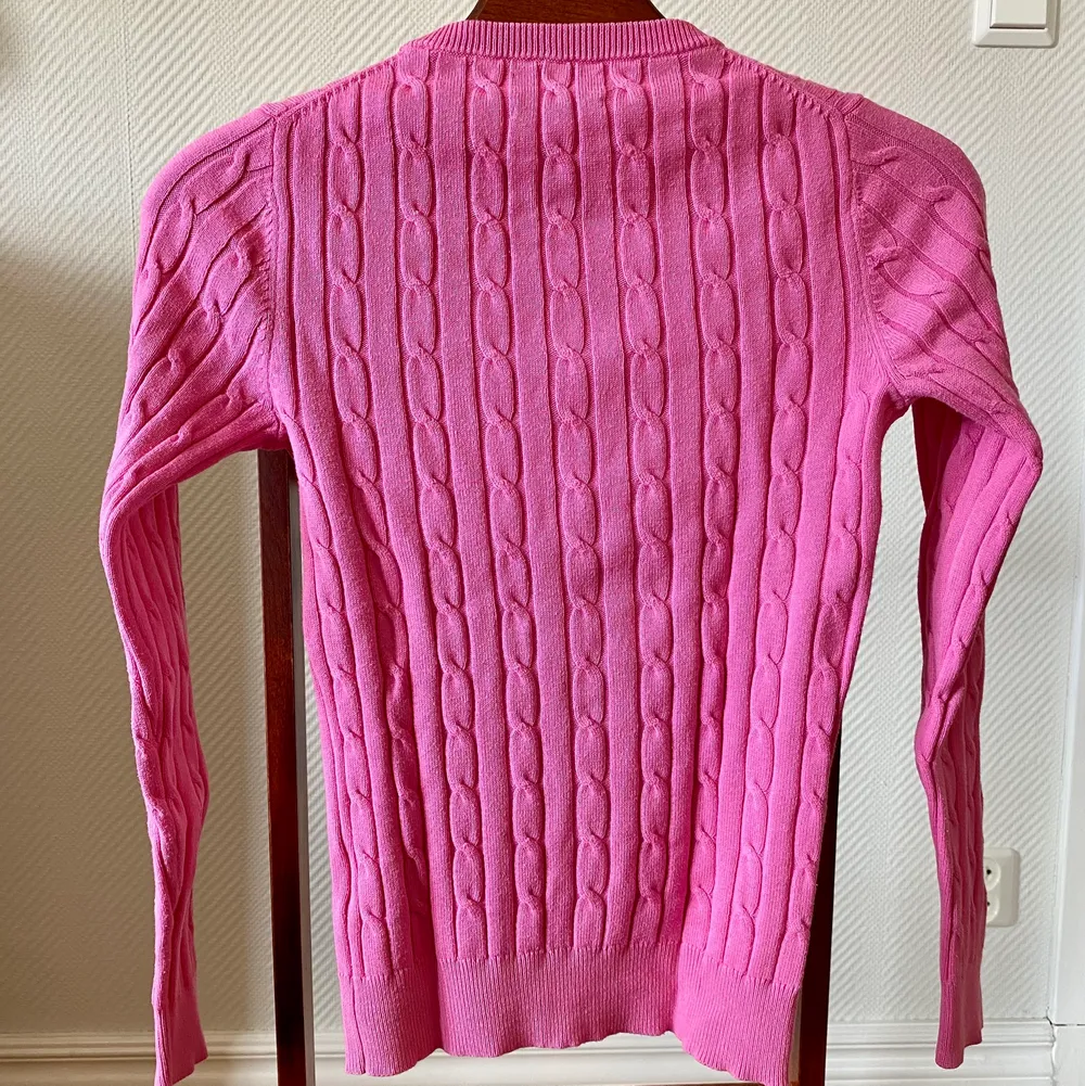 Ljusrosa, figursydd, kabelstickad tröja från Gant i storlek xxs, 32. Tröjan är köpt av mig i en Gantaffär och är i nyskick, använd 2 gånger.  Material: bomull, polyamid, elastan. Stickat.