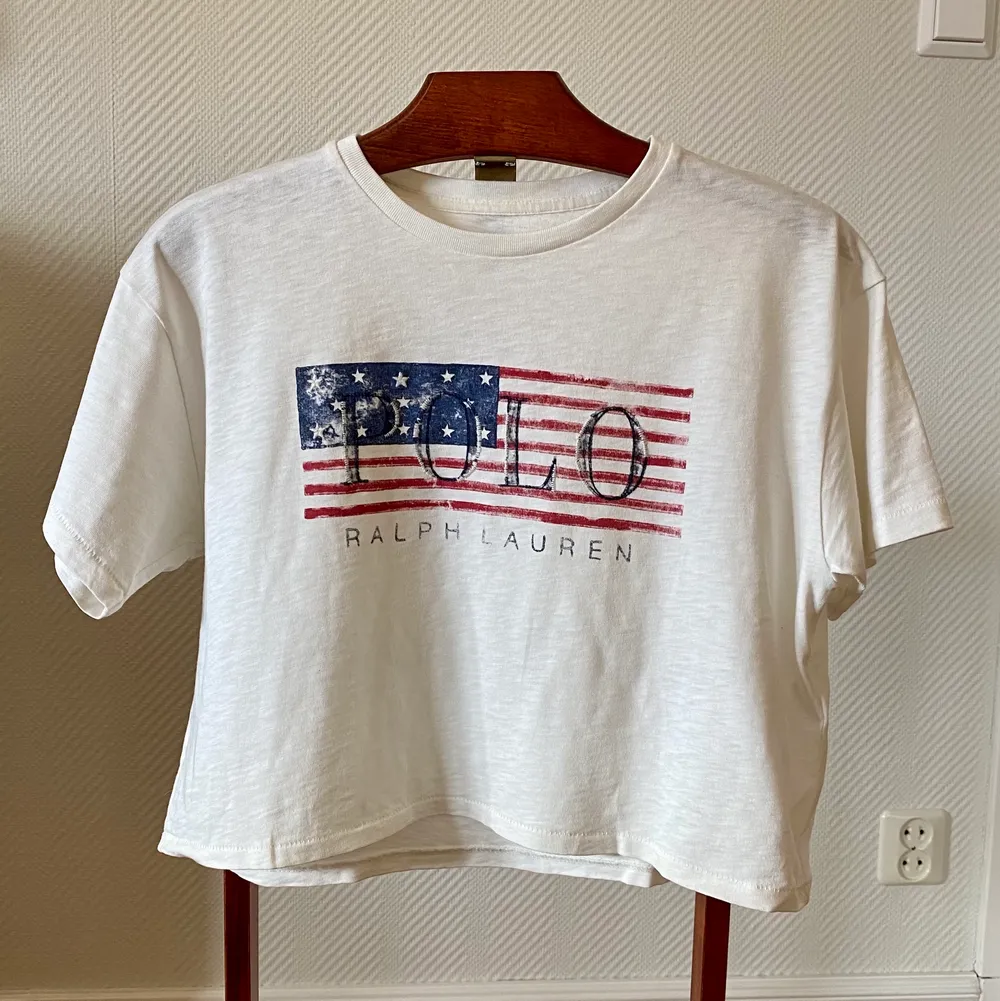 Vit T-shirt (magtröja), med tryck och text från Polo Ralph Lauren i storlek xs, 34. Tröjan är köpt av mig på Best of brands och är i nyskick, använd 1 gång.   Material: bomull. T-shirts.