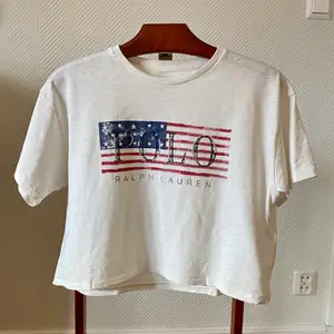 Vit T-shirt (magtröja), med tryck och text från Polo Ralph Lauren i storlek xs, 34. Tröjan är köpt av mig på Best of brands och är i nyskick, använd 1 gång.   Material: bomull