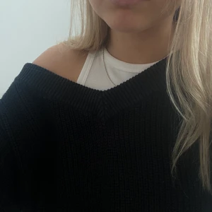 stickad tröja - Sparsamt använd svart stickad tröja med djup ringning. Passar superbra att styla med linne, bralette eller utan något alls under! Lite oversized. Köparen står för frakten!