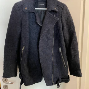 Kort kappa med bälte nedtill - Blå kappa, kort i modellen. Som ett bälte längst ner.