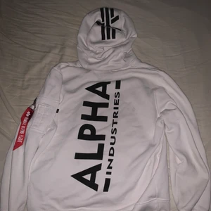 Alpha industries Hoodie  - De är en alpha industries vit hoodie med stort svart tryck på ryggen och ett litet vitt tryck med loggan på bröstet ifram och självklart den röda taggen på armen, använd fåtal gånger så den är väldigt fräsch och vit, säljes pågrund av att den är lite för stor för mig, det är storlek M och köpte den 1000 kr ny för några veckor sen mvh Liam 