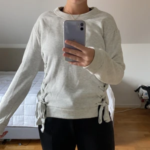 Ljus grå sweatshirt - En fin oanvänd ljus grå sweatshirt. Med två knyten på sidorna som man själv kan knyta. Är i storlek xs men passar mig som oftast har s-m💕 är i ett fint skick! 