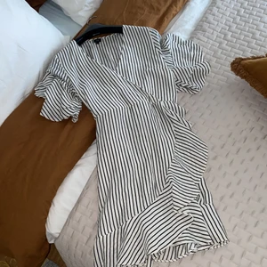 River Island omlottklänning - Randig omlottklänning strl 14 (42) men skulle säga att den sitter som en M (har själv S-M och passar bra). Går att justera. 