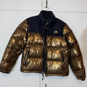 The North Face vinterjacka - Guld färgad super varm vinterjacka i väldigt gott skick. Säljer eftersom blev trött på den.