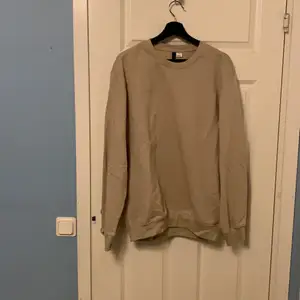 En beige och bekväm sweatshirt i storlek M