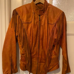 Skinnjacka med fransar  - Jättefin skinnjacka men fransar i supermjukt skinn. Som ny. Kort modell med lite smalare i midjan.