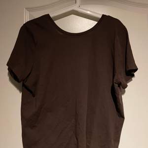 Aldrig använd Mörkbrun T-shirt med djup urringning i ryggen, från nakd. Köparen står själv för frakten 