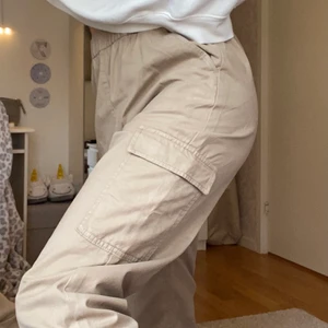 Cargobyxa i twill - Säljer dessa snygga cargopants i färgen ljusbeige. Byxorna är i materialet twill och har resår vid midjan och anklarna. Har använt ca 2-3 gånger men de är i perfekt skick.