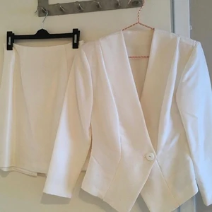 Vit dräkt i siden, jacka och kjol - Brudklädd?  Vit skräddarsydd dräkt i thaisiden (struktur i tyget) storlek 36. Jacka+kort kjol, använd endast en gång,  (Finns även sidenstr till, i en annan annons!)