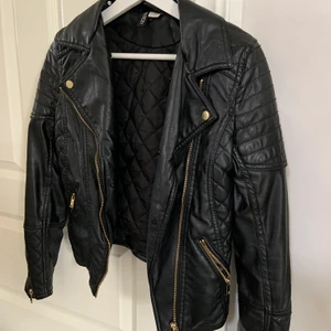 En svart skinnjacka  - En svart skinnjacka med guldiga detaljer. Storlek 34 ifrån hm divided. Säljer eftersom den är för liten för mig🥰🥰