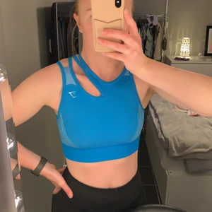 Gymshark Ultra Seamless Sports Bra Blue Strl M - Säljer den här snygga toppen från Gymshark. Köpt begagnad från tradera men aldrig använd av mig. Superskön och stretchig men inte riktigt min färg. Hoppas att den kan komma till användning av någon annan. Köpare står för frakten 😃 