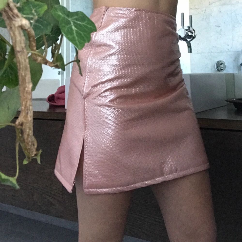 Shiny tight pink skirt Non strechty fabric  With a pink zipper                                                           Mesuranse : Waist 68 cm Length 46cm . Kjolar.